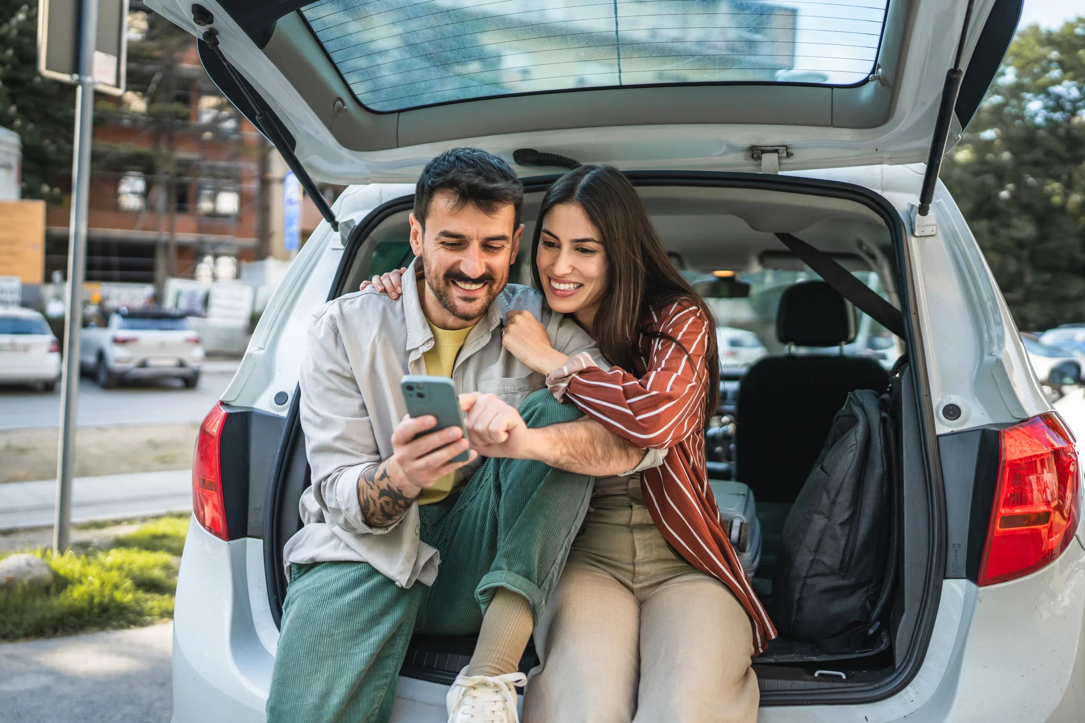 Una pareja junto al baúl abierto de su auto